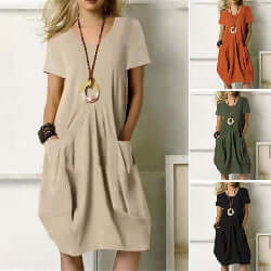 Woman wearing a beige cotton and linen short sleeve dress with a round neckline, from Infinity Bazaar, styled with a relaxed fit